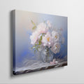 Framed canvas print of elegant pink peonies in an ornate glass vase portrayed with soft pastel colors