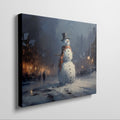 Framed canvas print of a snowman in a winter evening townscape with warm street lights and snowfall